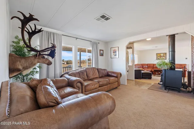 a living room with furniture a mirror and a floor to ceiling window