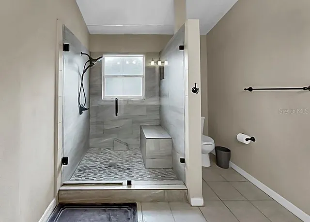 a bathroom with a granite countertop sink a toilet and shower