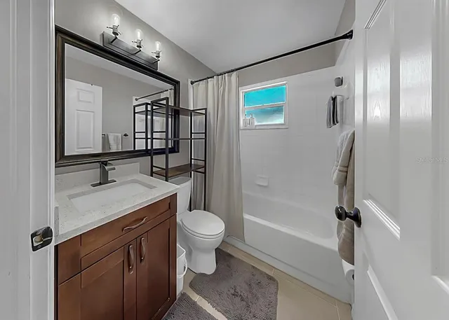 a bathroom with a sink toilet a mirror and shower