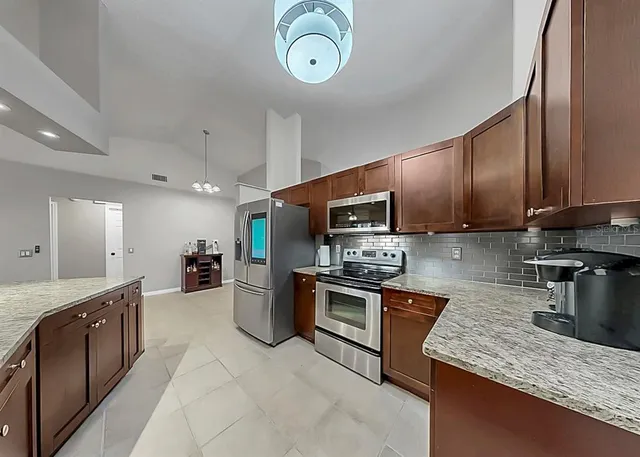 a large kitchen with stainless steel appliances granite countertop a stove oven and a sink with granite countertops
