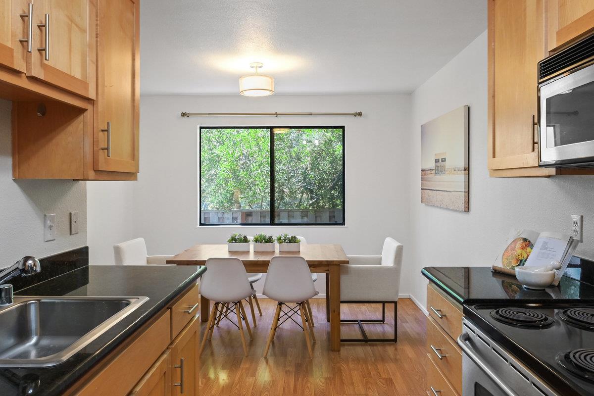 900 Cambridge Drive, Unit 181 Benicia, CA 94510 - Photo 9 of 38 a kitchen with stainless steel appliances granite countertop a stove top oven a dining table and chairs with wooden floor