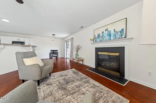 a living room with furniture a fireplace and a flat screen tv