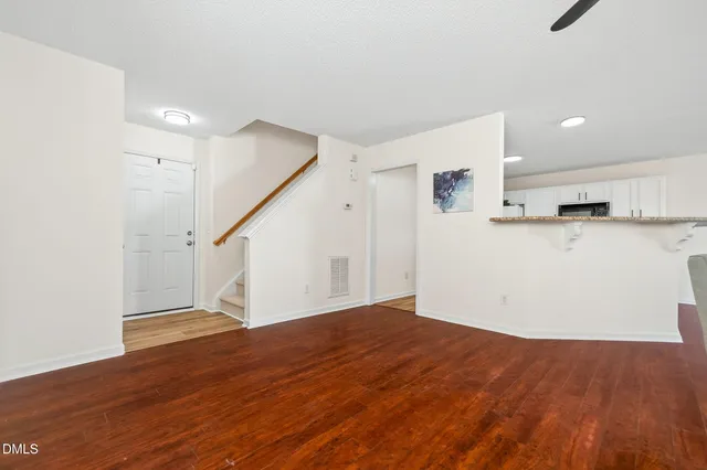 a view of a kitchen with wooden floor and a ceiling fan