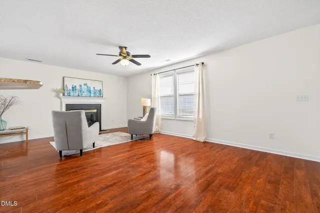 a view of a livingroom with wooden floor and a ceiling fan