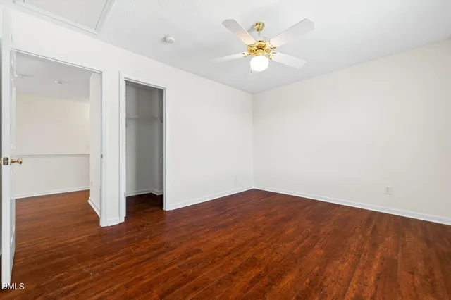 an empty room with wooden floor and window
