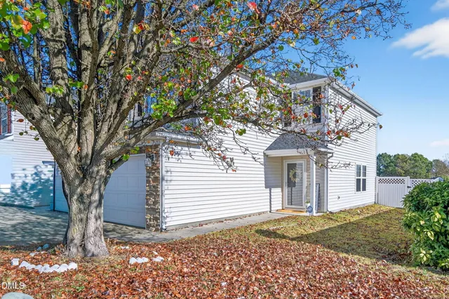 a view of a house with a tree in the yard