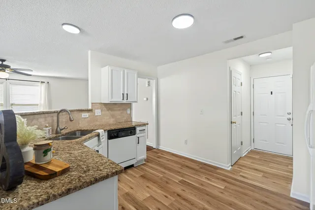 a kitchen with granite countertop a sink and a stove top oven