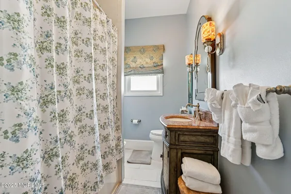 a bathroom with a granite countertop toilet sink and mirror