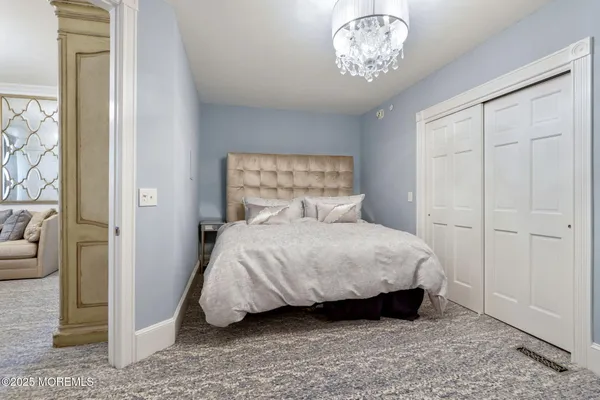a bedroom with a bed and a chandelier