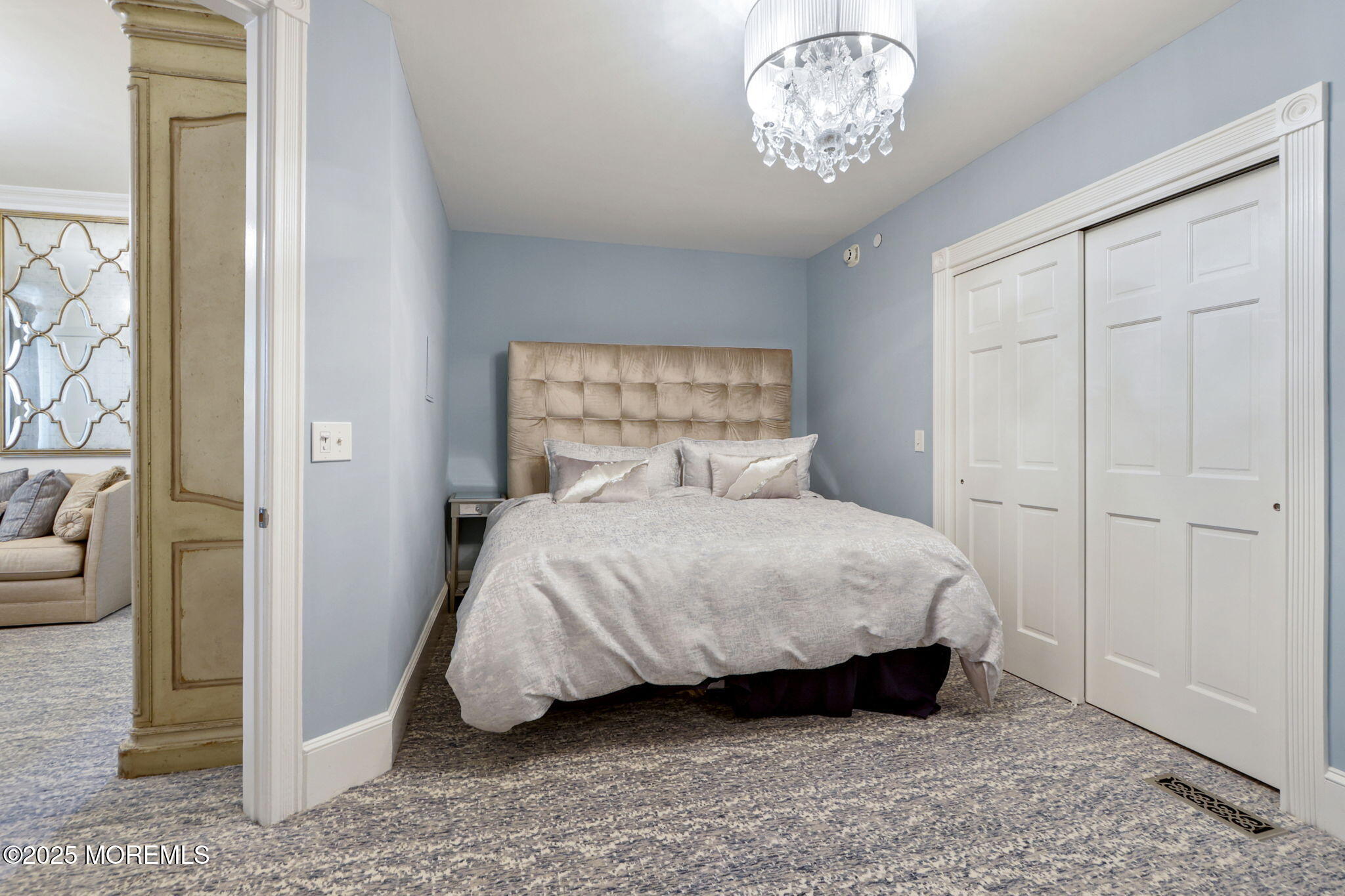 200 Monmouth Avenue, Unit 19 Spring Lake, NJ 07762 - Photo 9 of 28 a bedroom with a bed and a chandelier