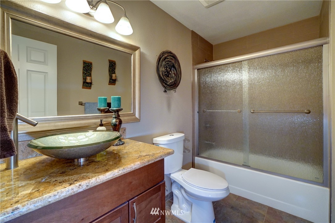 2831 Whitworth Avenue South Renton, WA 98055 - Photo 29 of 40 a bathroom with a granite countertop toilet a sink and a mirror