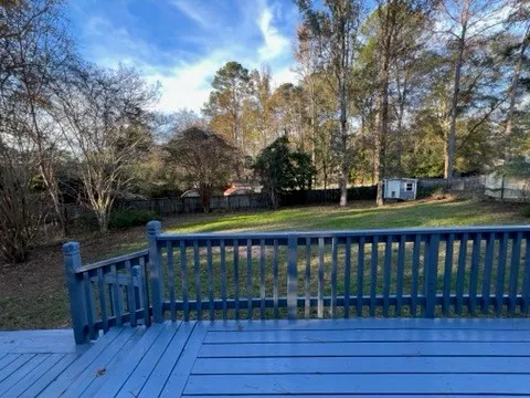 a view of deck with wooden floor and trees