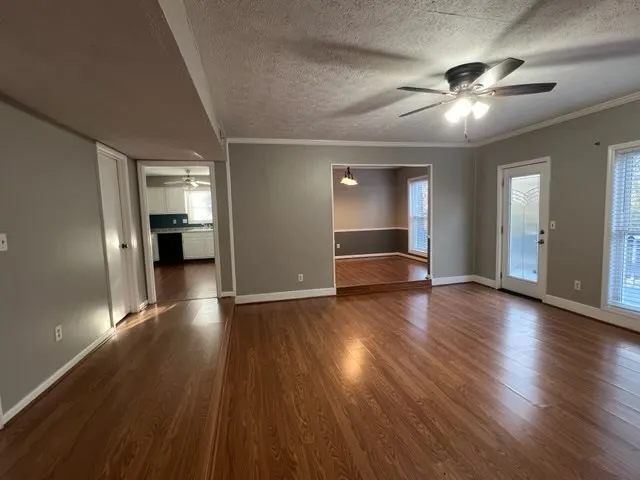 a view of empty room with wooden floor