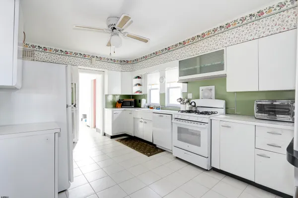 a kitchen with white cabinets and white appliances