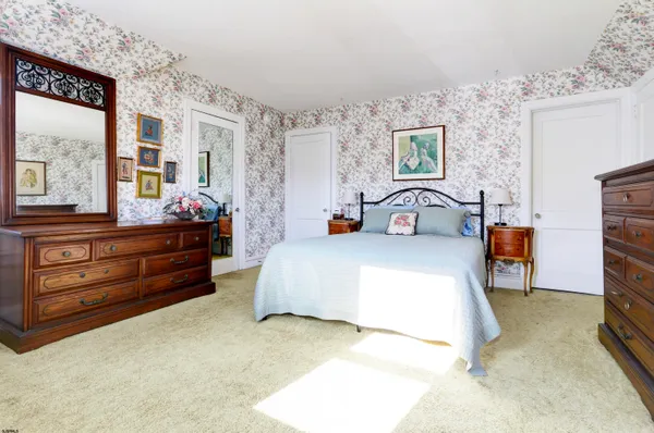 a bedroom with a bed and large windows