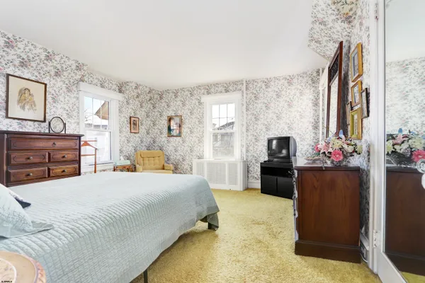 a bedroom with a bed dresser and window