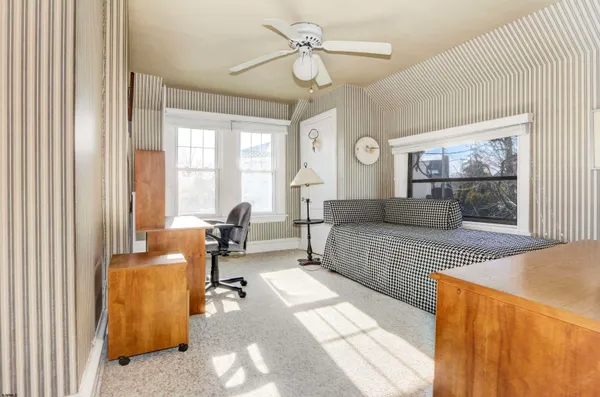 a bedroom with furniture and large windows