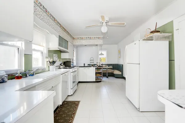 a kitchen with a refrigerator a sink and white cabinets