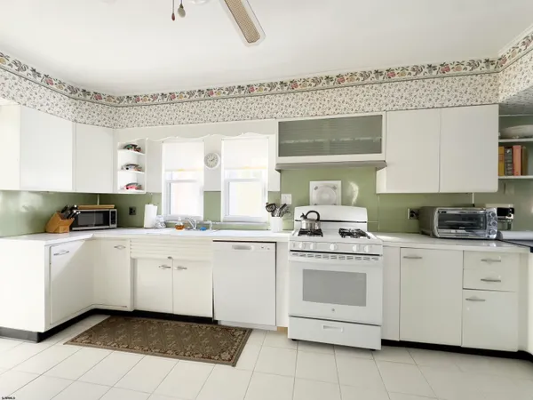 a kitchen with white cabinets and white appliances