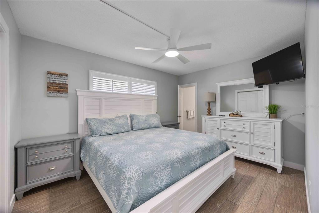 6150 Midnight Pass Road, Unit 10 A&B Sarasota, FL 34242 - Photo 17 of 65 a bedroom with a large bed and a flat tv screen on dresser