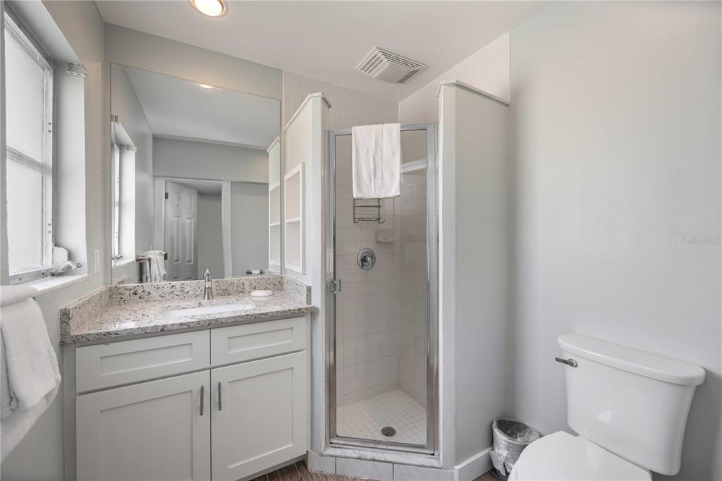 6150 Midnight Pass Road, Unit 10 A&B Sarasota, FL 34242 - Photo 21 of 65 a bathroom with a granite countertop sink toilet and shower