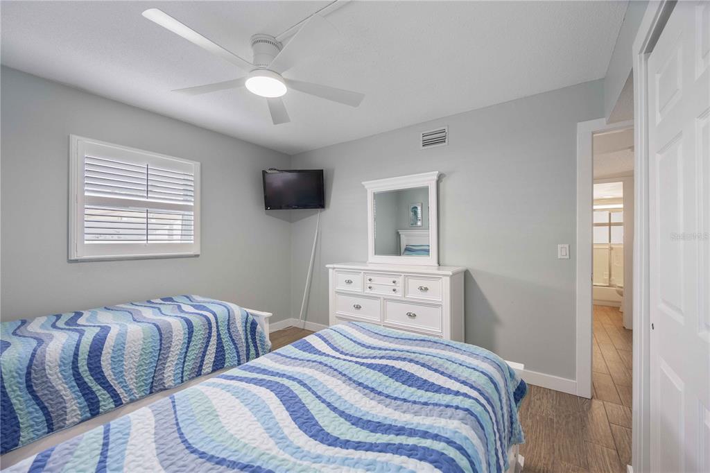 6150 Midnight Pass Road, Unit 10 A&B Sarasota, FL 34242 - Photo 23 of 65 a bedroom with two beds and a flat screen tv