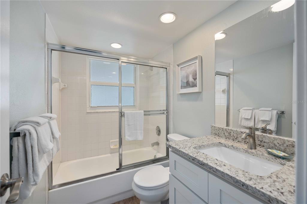 6150 Midnight Pass Road, Unit 10 A&B Sarasota, FL 34242 - Photo 25 of 65 a bathroom with a granite countertop sink toilet and shower