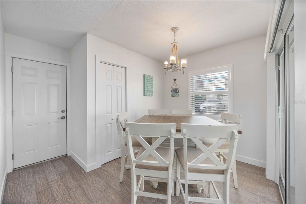6150 Midnight Pass Road, Unit 10 A&B Sarasota, FL 34242 - Photo 3 of 65 a view of a dining room with furniture wooden floor and chandelier