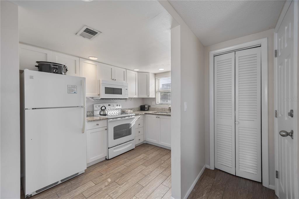 6150 Midnight Pass Road, Unit 10 A&B Sarasota, FL 34242 - Photo 32 of 65 a kitchen with white cabinets and white stainless steel appliances
