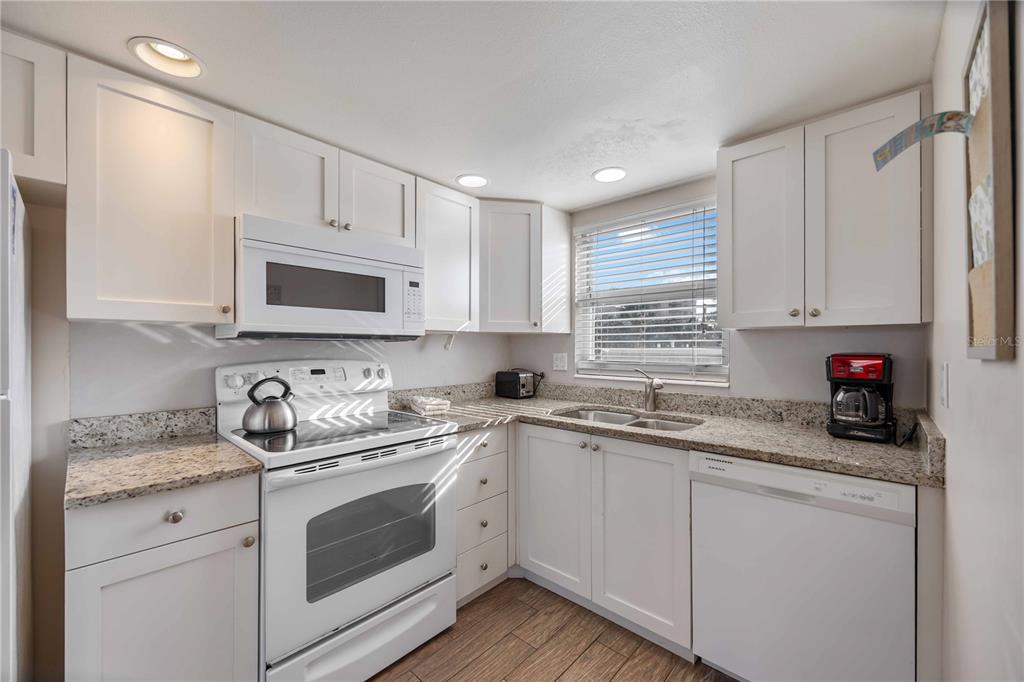 6150 Midnight Pass Road, Unit 10 A&B Sarasota, FL 34242 - Photo 33 of 65 a kitchen with appliances a sink and cabinets