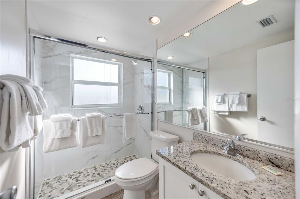 6150 Midnight Pass Road, Unit 10 A&B Sarasota, FL 34242 - Photo 45 of 65 a spacious bathroom with a granite countertop tub sink a mirror a toilet and shower