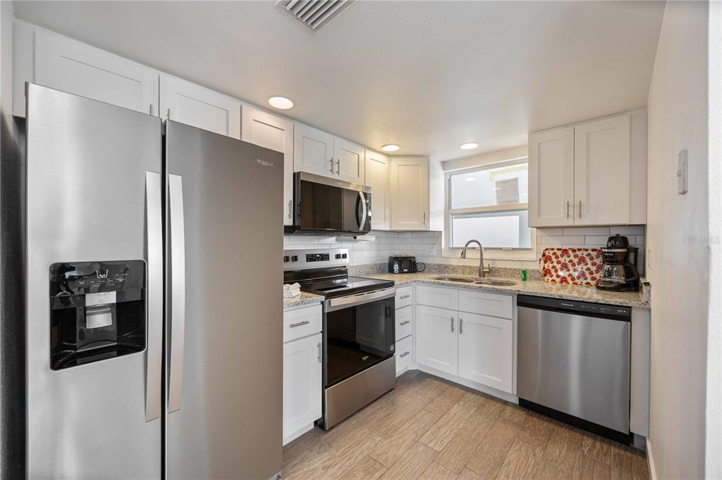 6150 Midnight Pass Road, Unit 10 A&B Sarasota, FL 34242 - Photo 8 of 65 a kitchen with stainless steel appliances a refrigerator sink and stove top oven
