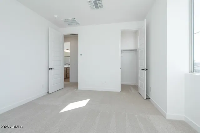 an empty room with closet and a bathroom