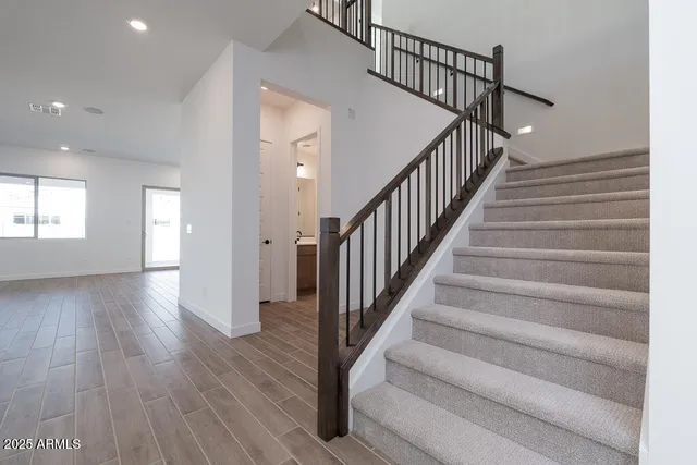 a view of staircase with wooden floor and fan
