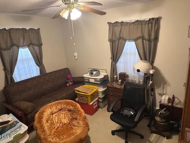 a view of a workspace with furniture and a window