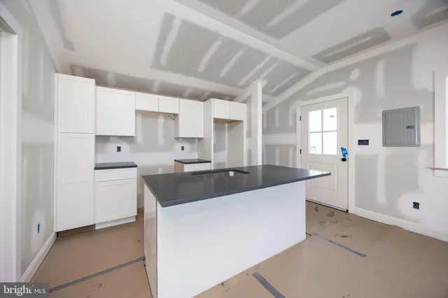 a view of a kitchen with white cabinets