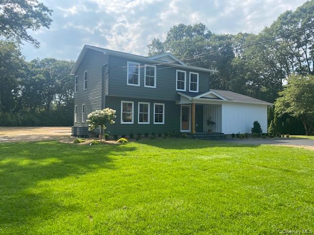 444 Miller Place Road Miller Place, NY 11764 - Photo 1 of 1 View of front of property featuring a front yard, covered porch, and view of scattered trees