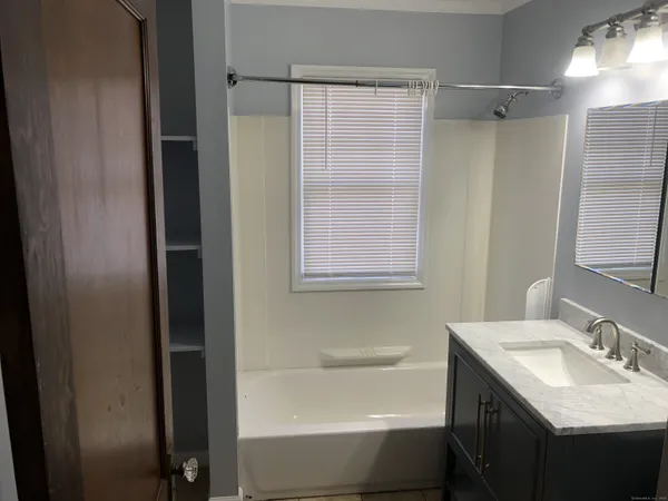 a bathroom with a granite countertop sink toilet and shower