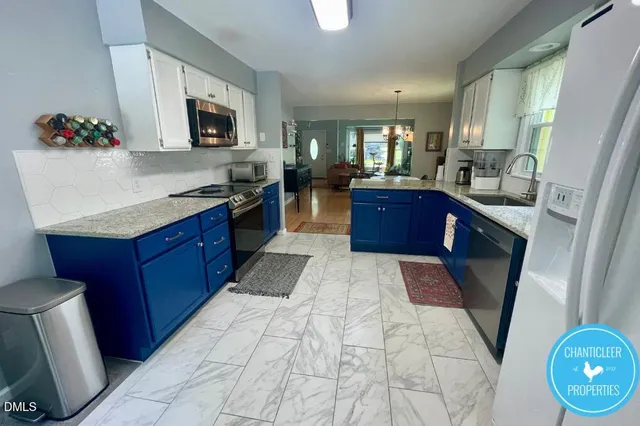 a large kitchen with stainless steel appliances kitchen island granite countertop a refrigerator a stove top oven a sink dishwasher and wooden cabinets with island