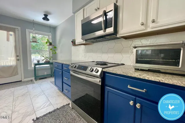 a kitchen with stainless steel appliances granite countertop a stove a microwave and a sink