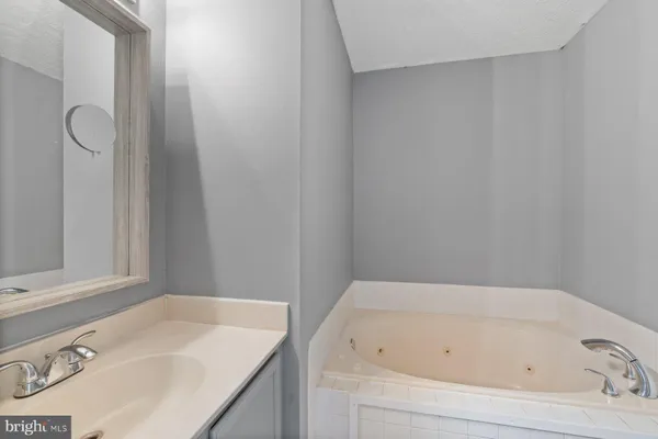 a bathroom with a tub sink and vanity