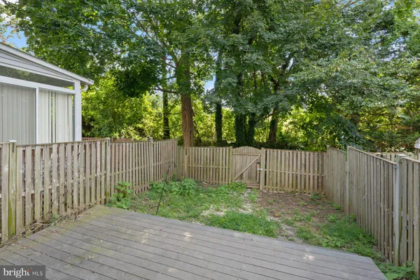 a view of backyard with wooden fence and trees