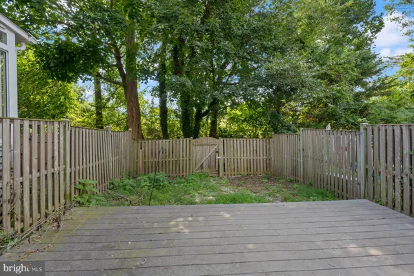 a wooden deck with trees in front of it