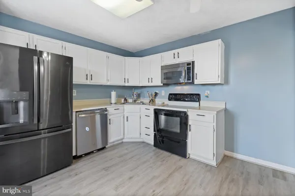 a kitchen with a refrigerator stove and white cabinets
