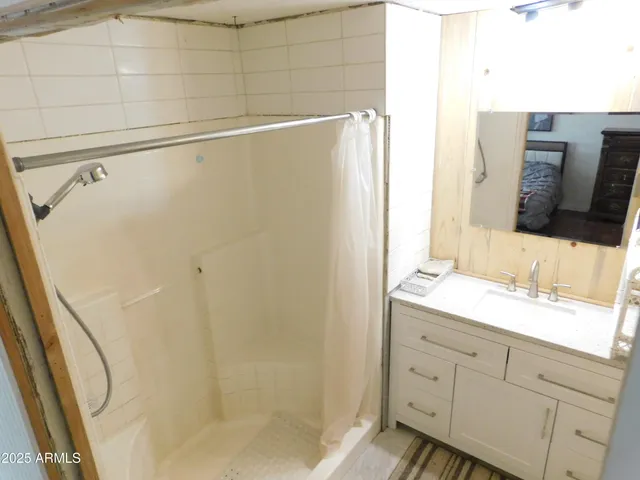 a bathroom with a granite countertop sink a mirror and shower