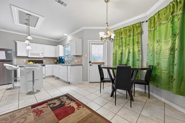 a open kitchen with stainless steel appliances granite countertop a stove a sink dishwasher a dining table and chairs with wooden floor