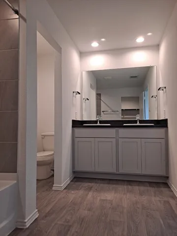 a bathroom with a sink a toilet and mirror