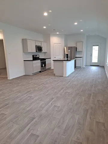 a view of kitchen with wooden floor and electronic appliances