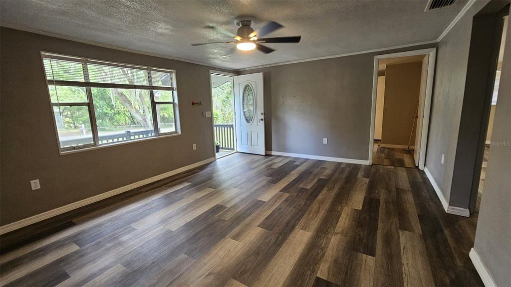 36850 Haynes Road Fruitland Park, FL 34731 - Photo 8 of 28 a view of empty room with wooden floor and fan