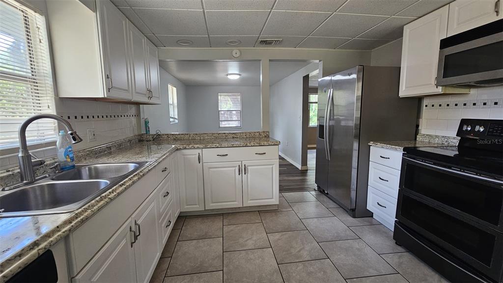 36850 Haynes Road Fruitland Park, FL 34731 - Photo 9 of 28 a kitchen with a sink stove and refrigerator